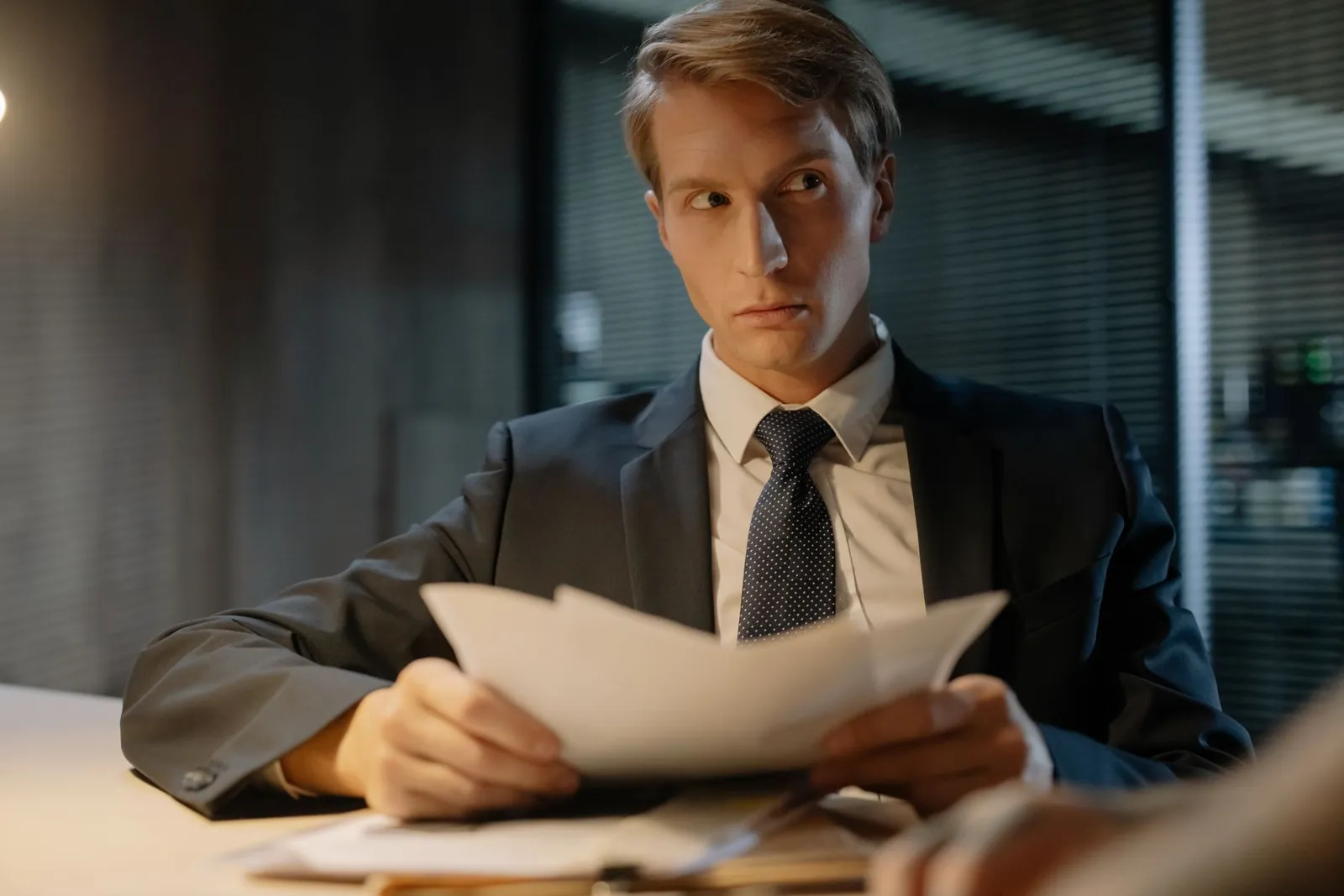Professional in a suit carefully reviewing corporate documents
