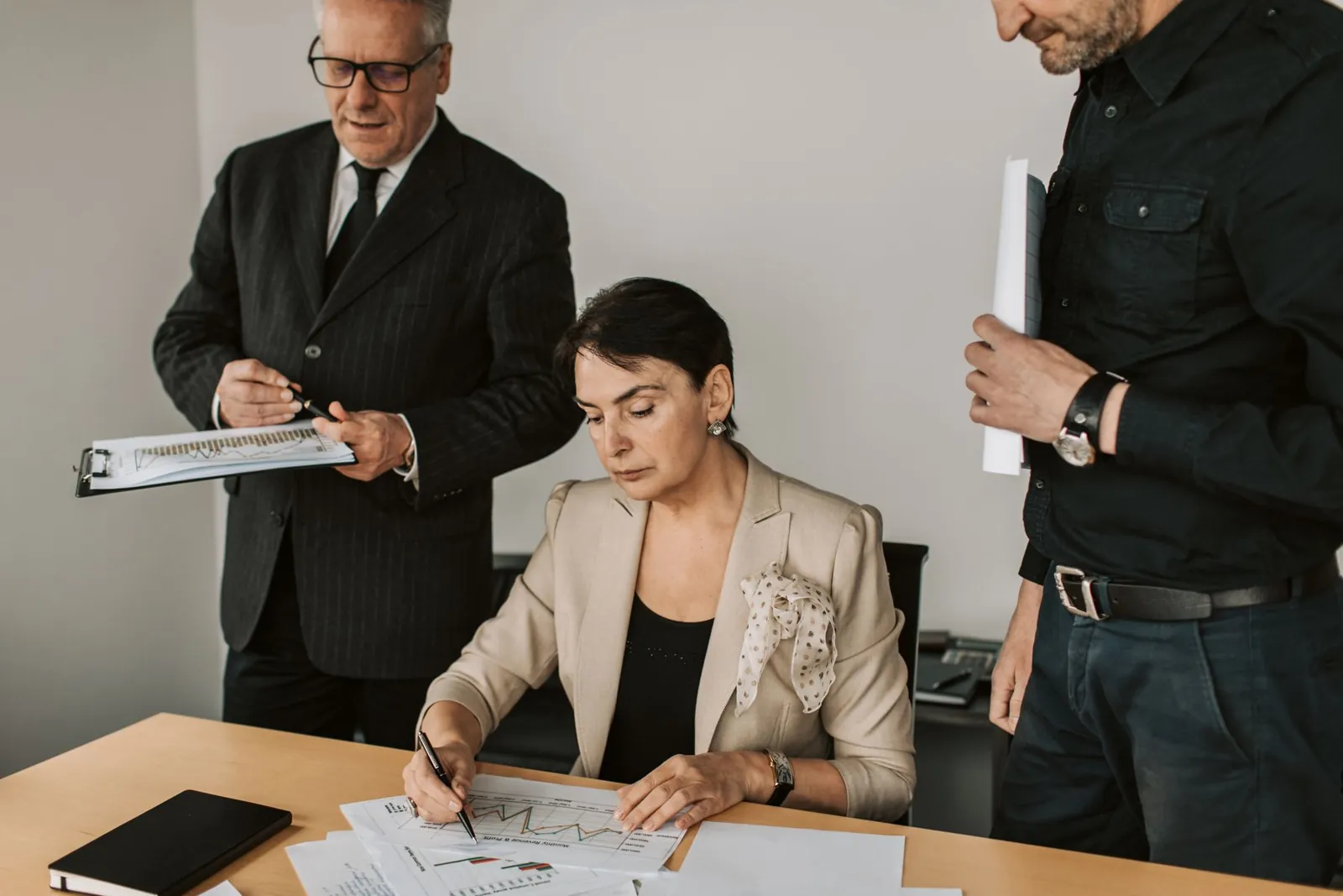 Director signing board resolutions while the company secretary stands by with the minute book