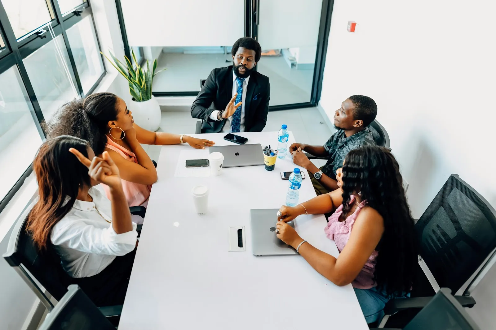 Executives in a board meeting around a long white boardroom table
