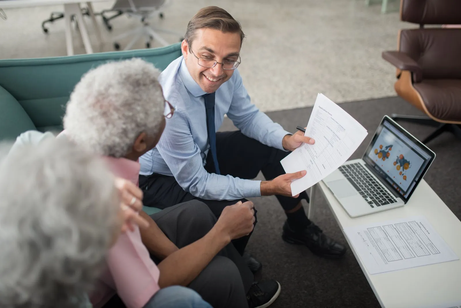 Tax advisor walking a client through figures on paper and laptop